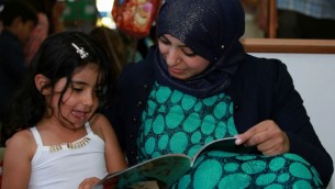 مشروع "مكتبة الفانوس" يحفز على مشاركة القراءة بين الأهل والطفل. (Rami Jabareen)