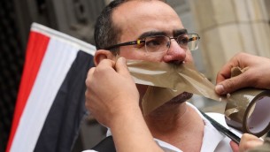 متظاهر يضع الشريط اللاصق على فمه للدلالة على حملة القمع التي تشنها السلطات المصرية ضد حرية التعبير خلال مظاهرة امام سجن في برلين حيث يحتجز الصحافي المصري احمد منصور، 22 يونيو 2015 (ADAM BERRY / AFP)