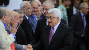رئيس السلطة الفلسطينية محمود عباس ورئيس وزرائه رامي الحمد الله يلقون التحية على أعضاء حكومة التوافق الفلسطينية الجديدة في مدينة رام الله بالضفة الغربية، 2 يونيو، 2014. (AFP /ABBAS MOMANI)
