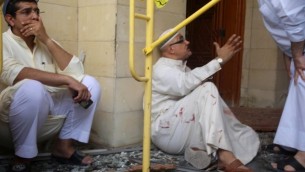 مصابون خارج مسجد "الإمام الصادق" الشيعي بعد إستهدافه في هجوم إنتحاري خلال صلاة الجمعة في 26 يونيو، 2015، في مدينة الكويت (AFP PHOTO / YASSER AL-ZAYYAT)