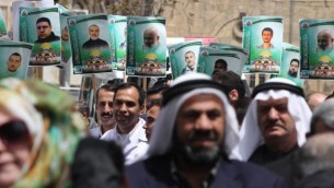 صور اعضاء في حركة حماس المسجونين في السجون الإسرائيلية خلال مظاهرة في الخليل، 15 ابريل 2015  (AFP PHOTO/HAZEM BADER)