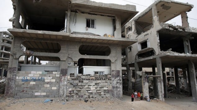 اطفال فلسطينيون بجانب منزلهم المدمر الذي وضع داخله ثلاث غرف جاهزة في حي الشجاعية في غزة، 11 مايو 2015 (THOMAS COEX / AFP) اطفال فلسطينيون بجانب منزلهم المدمر الذي وضع داخله ثلاث غرف جاهزة في حي الشجاعية في غزة، 11 مايو 2015 (THOMAS COEX / AFP)