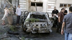 فلسطينيون يحتشدون حول سيارة محترقة في مدينة غزة في 19 يوليو، 2015، بعد أن دمرت سلسلة من الإنفجارات 5 مركبات في غزة تابعة لأعضاء في حركتي حماس والجهاد الإسلامي، بحسب شهود عيان ومصادر أمنية، في خضم توترات بين حكام القطاع الفلسطيني ومتطرفين إسلاميين. (AFP/MOHAMMED ABED)
