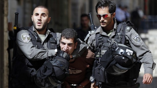 قوات الأمن الإسرائيلية تعتقل رجل فلسطيني خلال اشتباكات بين متظاهرين فلسطينيين والشرطة الإسرائيلية في البلدة القديمة في القدس، 26 يوليو 2015 (AFP PHOTO / AHMAD GHARABLI)