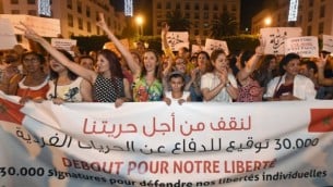 مغاربة يطلقون هتافات ويحملون لافتات خلال تظاهرة في الرباط ضد إعتقال فتاتين مغربيتين بسبب إرتداء تنورة، 6 يوليو، 2015. (AFP/FADEL SENNA)
