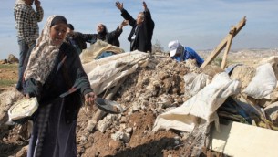 فلسطينيون يحاولون إسترداد أغراض تابعة لهم من أتقاض منزل بعد قيام جرافات الجيش الإسرائيلي بتدميره بالقرب من قرية سوسيا بالضفة الغربية في 2011. (Najeh Hashlamoun/Flash90)