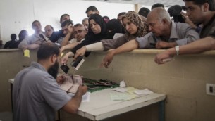 فلسطينيون يحتشدون عند معبر رفح الحدودي جنوب قطاع غزة، خلال إنتظارهم الحصول على تصريحات لدخول مصر في 12 يونيو، 2015. (Flash90/Aaed Tayeh)
