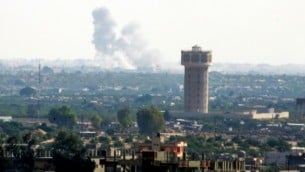 تصاعد الدخان في شمال سيناء، كما يظهر من الحدود مع قطاع غزة، في خضم إشتباكات عنيفة بين قوات الحكومة ومسلحين تابعين لتنظيم "الدولة الإسلامية" في 1 يوليو، 2015. (Abed Rahim Khatib/Flash90)