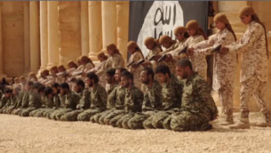 صورة شاشة لشريط نشره تنظيم الدولة الإسلامية يظهر اعدام 25 من جنود القوات السورية النظامية بايدي فتيان وسط اثار مدينة تدمر (YouTube)