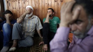 اقرباء الرضيع الفلسطيني علي دوابشة، يحدون بالقرب من جثمانه داخل مسجد خلال تشييع جثمانه في بلدة دوما في الضفة الغربية، 31 يوليو 2015 (AFP PHOTO / THOMAS COEX)