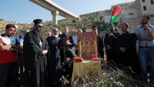 كهنة ومحتجون مسيحيون فلسطينيون يشاركون بصلاة جميعية احتجاجا على بناء اسرائيل للجدار الأمني في وادي كريمزان وبيت جالا، 18 اغسطس 2015 (MUSA AL-SHAER / AFP)