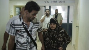 معزوزة علان (من اليمين)، والدة الأسير الفلسطيني محمد علان، خارج غرفة إبنها بعد قيامها بزيارته في مركز "برزيلاي" الطبي في مدينة أشكلون جنوبي إسرائيل في 20 أغسطس، 2015. (Ahmad Gharabli/AFP)