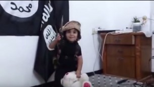 طفل يقوم بقطع رأس دمية دب في مقطع فيديو بأسلوب "الدولة الإسلامية". (لقطة شاشة من YouTube)