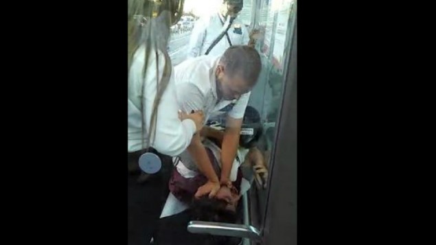 حارس في محطة للقطار الخفيف يهاجم سائح أمريكي قي شريط الفيديو هذا الذي تم بثه في 3 أغسطس، 2015 على القناة 10. (لقطة شاشة) حارس في محطة للقطار الخفيف يهاجم سائح أمريكي قي شريط الفيديو هذا الذي تم بثه في 3 أغسطس، 2015 على القناة 10. (لقطة شاشة)