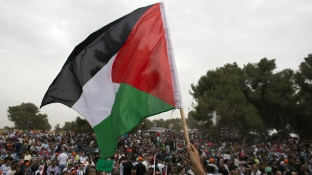 صورة توضيحية لرفع علم فلسطين (AFP/Ahmad Gharabli) صورة توضيحية لرفع علم فلسطين (AFP/Ahmad Gharabli)