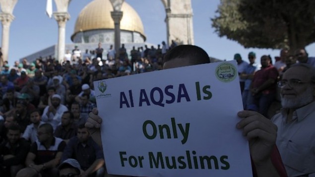 فلسطينيون يتظاهرون امام قبة الصخرة يرفعون لافة مكتوب عليها ان "الأقصى للمسلمين فقط"، 27 سبتمبر 2015 (AFP PHOTO/AHMAD GHARABLI)
