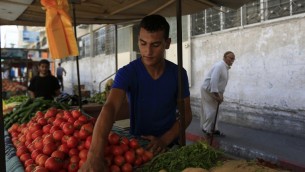 معمر قويدر يبيع الخضروات في بسطته في مدينة غزة، 29 سبتمبر 2015 (MOHAMMED ABED / AFP)