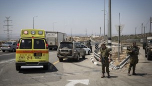 سيارة إسعاف تقوم بإجلاء  رجل فلسطيني أُصيب بجراح طفيفة بعد تعرضه لإطلاق النار بعد طعنه لجندي إسرائيلي في حاجز "بل"، على طريق رقم 443، 15 أغسطس، 2015. (Hadas Parush/Flash90)