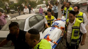 طاقم من "زاكا" يحمل حثة في حي "روميما" في القدس، حيث تم العثور على زوجين ميتين جراء إستنشاقهما للغاز، الثلاثاء، 8 سبتمبر، 2015. (Yonatan Sindel/Flash90)