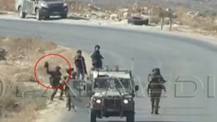 صورة التقطت من شريط فيديو في الضفة الغربية يظهر جندي اسرائيلي يرمي ما يبدو انها كاميرا تابعة لصحفيين في وكالة فرانس برس، 25 سبتمبر 2015 (screen capture: YouTube)