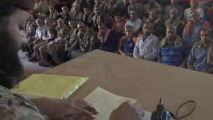 عناصر تنظيم ’الدولة الإسلامية’ يجبرون المسيحيين في مدينة ’القريتين’ السورية على التوقيع على عقد لغير المسلمين، في صورة تم نشرها في 3 سبتبمر، 2015. ( MEMRI)