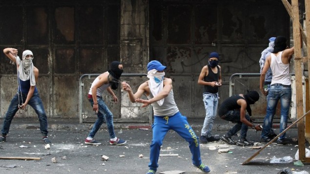 فلسطينيون يلقون الحجارة تجاه قوات الأمن الإسرائيلية خلال مواجهات في مدينة الخليل بالضفة الغربية، 4 أكتوبر، 2015. (AFP/ HAZEM BADER) فلسطينيون يلقون الحجارة تجاه قوات الأمن الإسرائيلية خلال مواجهات في مدينة الخليل بالضفة الغربية، 4 أكتوبر، 2015. (AFP/ HAZEM BADER)