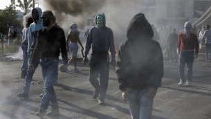 ملثمون راشقو حجارة فلسطينيين  خلال اشتباكات مع قوات الأمن الإسرائيلية في بيت ايل (مستوطنة يهودية)، شمالي مدينة رام الله في الضفة الغربية  9 أكتوبر 2015 AFP PHOTO / ABBAS MOMANI