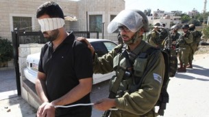 قوات الأمن الإسرائيلية تعتقل فلسطيني خلال مواجهات في قرية بيت عمر القريبة من مدينة الخليل، في الضفة الغربية، 11 أكتوبر، 2015. (AFP/Hazem Bader)