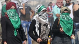 طالبات فلسطينيات من جامعة "بوليتكنك فلسطين" تقمن بإلقاء الحجارة باتجاه مستوطنة "بيت حاغاي" الإسرائيلية، عند المدخل الجنوبي لمدينة الخليل بالضفة الغربية، 18 أكتوبر، 2015. (AFP Photo/Hazem Bader)