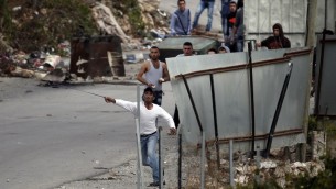 متظاهرون فلسطينيون يرشقون الحجارة باتجاه جنود اسرائيليين في مدخل بلدة بيت عنون بالقرب من الخليل، 26 اكتوبر 2015 (AFP/ THOMAS COEX)