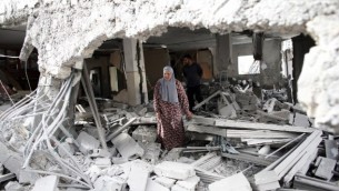 امرأة فلسطينية تسير وسط أنقاض منزل بعد أن قامت االقوات الإسرائيلية بهدم منزلين فلسطينيين قاما بتنفيذ هجمات، في حي جبل المكبر في القدس الشرقية، 6 أكتوبر، 2015. (AFP/THOMAS COEX)