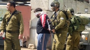 صورة توضيحية لجنود إسرائيليين يعتقلون فلسطينيين. (Najeh Hashlamoun/Flash90)