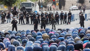 مصلون مسلمون وقوات الشرطة الإسرائيلية في حي وادي الجوز في القدس الشرقية، 9 أكتوبر، 2015. الشرطة الإسرائيلية أعلنت عن وضع قيود على سن الفلسطينيين الراغبين بدخول البلدة القديمة، وسمحت للجرال فوق سن ال45 فقط وجميع النساء بدخولها. (Yonatan Sindel/Flash90)