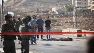 قوى الأمن الإسرائيلية بالقرب من جثة منفذ هجوم فلسطيني قام بطعن إسرائيلية ما أدى إلى إصابتها بجروج خطيرة بالقرب من مفترق آدم، شمال القدس. وقامت القوات الإسرائيلية بإطلاق النار على منفذ هجوم الطعن وقتله في موقع الهجوم، بحسب الجيش الإسرائيلي. 21 أكتوبر، 2015. (Yonatan Sindel/FLASH90).