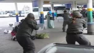 صورة شاشة لتصوير التقط بواسطة هاتف ذكي يظهر قوات الامن تحيط امرأة عربية من اسرائيل تحمل سكين بعد ان ورد انها حاولت طعن حارس في محطة الحافلات المركزية في العفولة، 9 اكتوبر 2015 (screen capture)