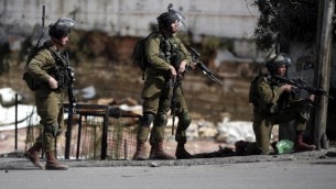 القوات الإسرائيلية تقف في شارع خلال مواجهات مع محتجين فلسطينيين في مدينة الخليل بالضفة الغربية، 30 أكتوبر، 2015. (AFP/Thomas Coex)
(AFP/Thomas Coex)