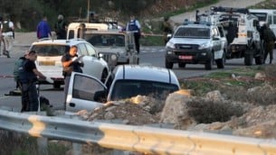 عناصر من الجيش والشرطة الإسرائيليين يقومون بتفتيش مركبة في أعقاب هجوم دام بالقرب من مستوطنة عوتنيئل، جنوبي مدينة الخليل بالضفة الغربية، 13 نوفمبر، 2015. (AFP/Hazem Bader)