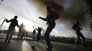 فلسطينيون يرشقون الحجارة باتجاه قوات الأمن الإسرائيلية خلال اشتباكات بالقرب من البيرة على ضواحي رام الله، 20 نوفمبر 2015 (AFP PHOTO/ABBAS MOMANI)