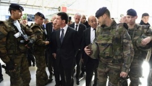 رئيس الوزراء الفرنسي مانويل فالس، في الوسط، يصل برفقة وزير الدفاع جان ايف لودريان ومسؤولين آخرين إلى محطة القطارات "غار دو نور" في باريس في 15 نوفمبر، 2015، للتحدث مع موظفي الشركة الوطنية الفرنسية لسكك الحديد حول الإجراءات الأمنية في أعقاب سلسلة من الهجمات المنسقة في باريس ومحيطها في 13 نوفمبر، 2015. (AFP/ERIC FEFERBERG)