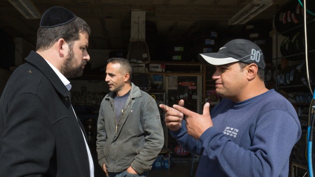 رجل يهودي متشدد من مستوطنة بيطار عليت يتحدث مع فلسطينيين اثناء غسل سيارته في الضفة الغربية، 11 نوفمبر 2015 (Nati Shohat/Flash90) رجل يهودي متشدد من مستوطنة بيطار عليت يتحدث مع فلسطينيين اثناء غسل سيارته في الضفة الغربية، 11 نوفمبر 2015 (Nati Shohat/Flash90)