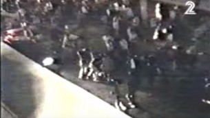 لقطة شاشة من شريط فيديو مصور هاو يظهر الحراس الشخصيين ورجال الشرطة يهمون بالقفز على قاتل يتسحاق رابين، ييغال عامير، في تل أبيب، 4 نوفبمر، 1995. (لقطة شاشة: عبر YouTube)