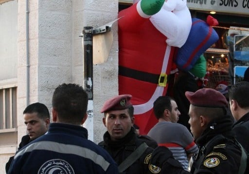 قوى الأمن والخدمات الطبية العسكرية خارج كنيسة المهد حيث يحتشد المسيحيون لإحتفالات الميلاد في مدينة بيت لحم بالضفة الغربية، 24 ديسمبر، 2015. (AFP/Musa al-Shaer)