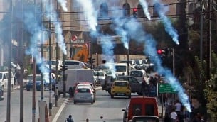 محتجون فلسطينيون يركضون للإحتماء من الغاز المسيل للدموع الذي تطلقة القوات الإسرائيلية خلال مواجهات في مدينة بيت لحم في الضفة الغربية، 2 أكتوبر، 2015. (Musa al Shaer/AFP)