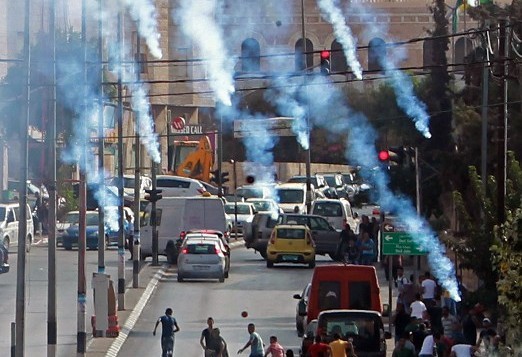 محتجون فلسطينيون يركضون للإحتماء من الغاز المسيل للدموع الذي تطلقة القوات الإسرائيلية خلال مواجهات في مدينة بيت لحم في الضفة الغربية، 2 أكتوبر، 2015. (Musa al Shaer/AFP)