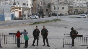 (ارشيف) مستوطنون يهود وعناصر شرطة الحدود الإسرائيلية امام ,بيت هماخبيلا’ في الخليل، ابريل 2012 (Miriam Alster/Flash90)