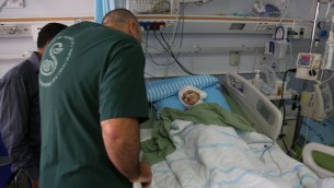 حسين دوابشة وطبيب بجانب سرير احمد دوابشة  في مركز شيبا الطبي في تال هشومير (Eric Cortellessa/Times of Israel)