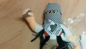 دمية ملثمة بكوفية وتحمل حجر صغير، عثر عليها في حاوية بطريقها الى السلطة الفلسطينية في مسناء حيفا، 8 ديسمبر 2015 (Haifa customs)