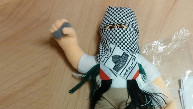 دمية ملثمة بكوفية وتحمل حجر صغير، عثر عليها في حاوية بطريقها الى السلطة الفلسطينية في مسناء حيفا، 8 ديسمبر 2015 (Haifa customs)
