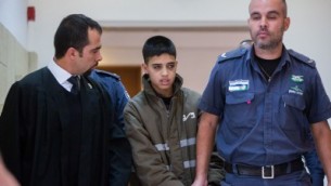 المحامي طارق برغوث مع موكله احمد مناصرة البالغ 13 عاما المتهم بالمشاركة بتنفيذ هجوم طعن في القدس، في المحكمة المركزية في القدس، 25 اكتوبر 2015 (Yonatan Sindel/Flash90)
