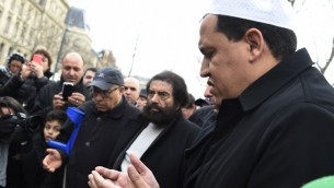 امام جامع درانسي يصلي خلال احياء ذكرى ضحايا الهجوم على صحيفة شارلي ايبدو الاسبوعية الساخرة وعلى متجر يهودي في شهر يناير الماضي في ساحة الجمهورية في باريس، 10 يناير 2016 (DOMINIQUE FAGET / AFP)